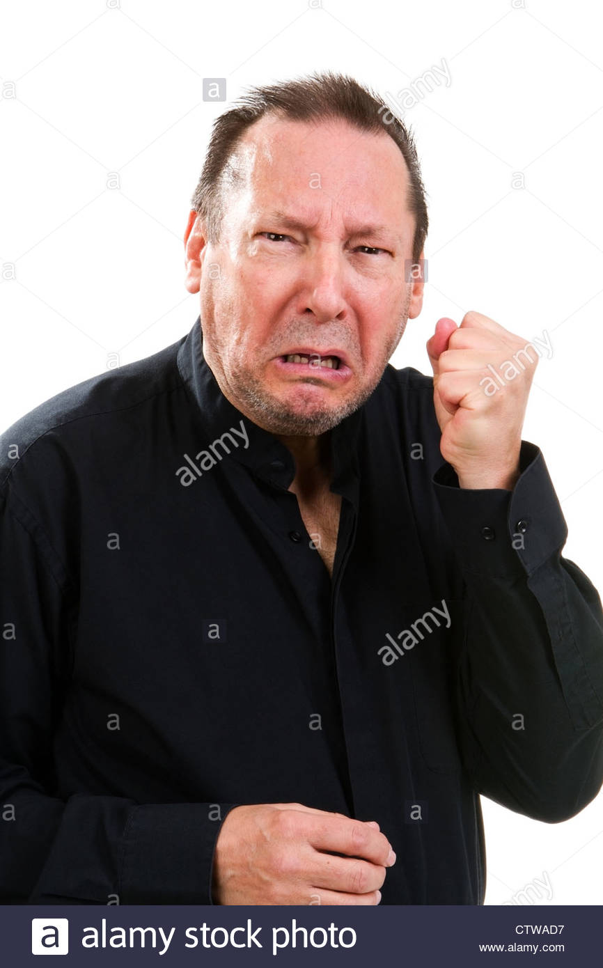 Combative elderly man clutches his fist with a agonized facial expression.  - Stock Image