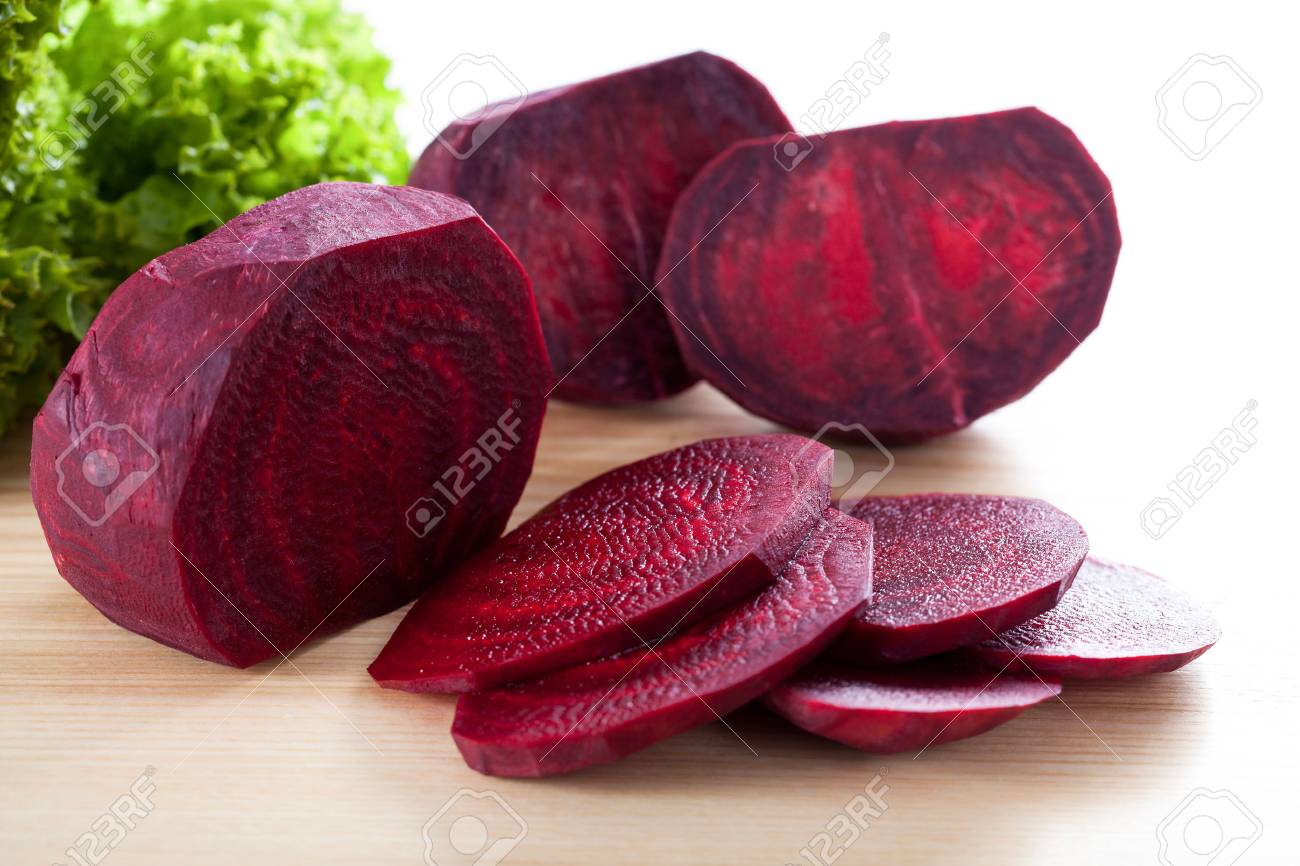 Purple sliced beetroot with fresh salad on wooden board Stock Photo -  23412002