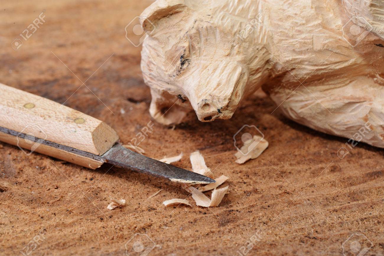 Macro shot of a wood carving knife some shavings and a carved figure Stock  Photo -