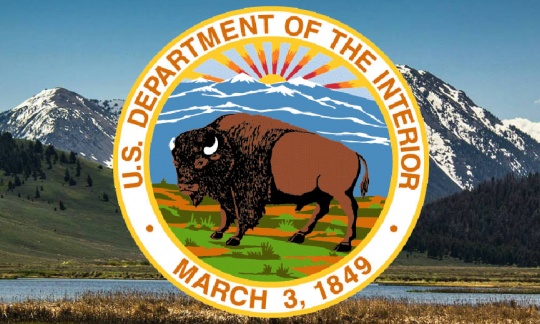 Department of the Interior bison seal set against green mountainous  background.