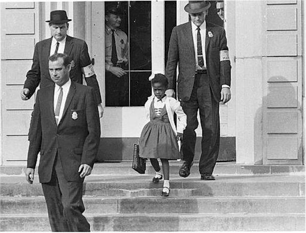 Ruby Bridges is escorted to school.
