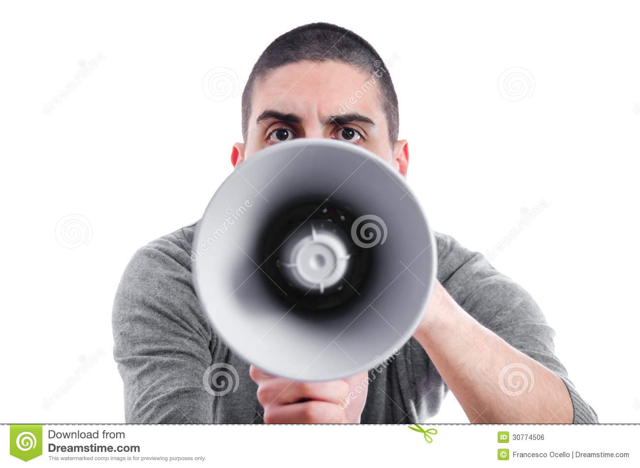 Angry frowning man shouting on a megaphone or loud haler which is partly  obscuring his face, isolated on white
