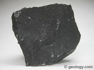 Basalt is a fine-grained, dark-colored extrusive igneous rock composed  mainly of plagioclase and pyroxene. The specimen shown is about two inches  (five