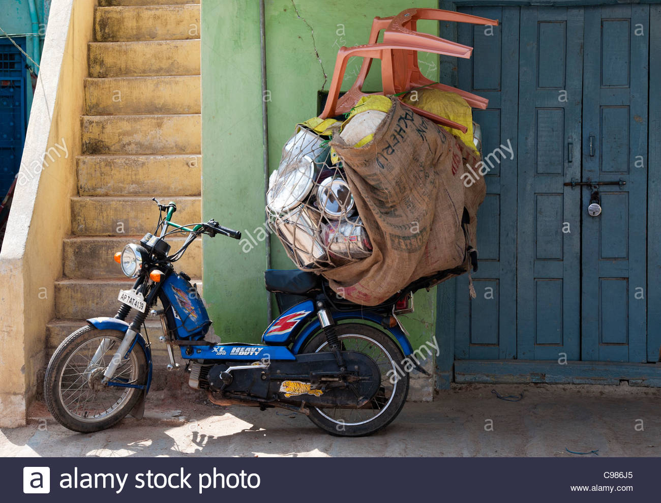 Indian moped ladened with goods to sell to local shops on the streets of  Puttaparthi, Andhra Pradesh, India