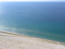 Lake view from the Sleeping Bear Dunes National Lakeshore, with people  climbing uphill